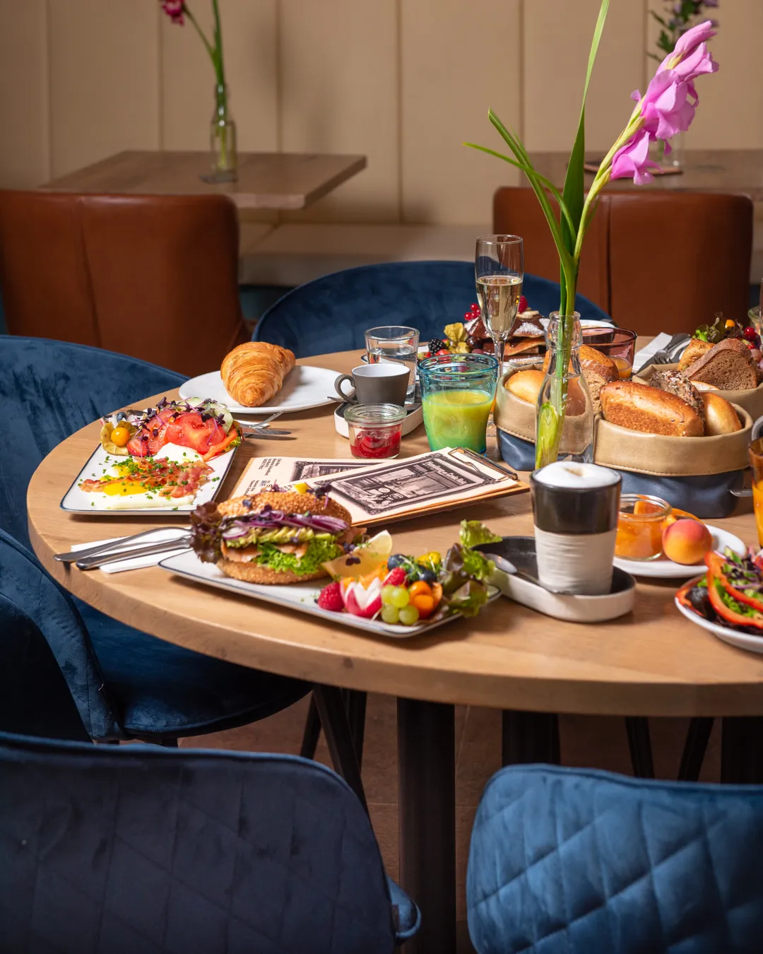 Stilvoll gedeckter Brunch-Tisch im Café Reis Gilching mit Bagel, Spiegeleiern mit Speck, Pancakes und Brotkorb