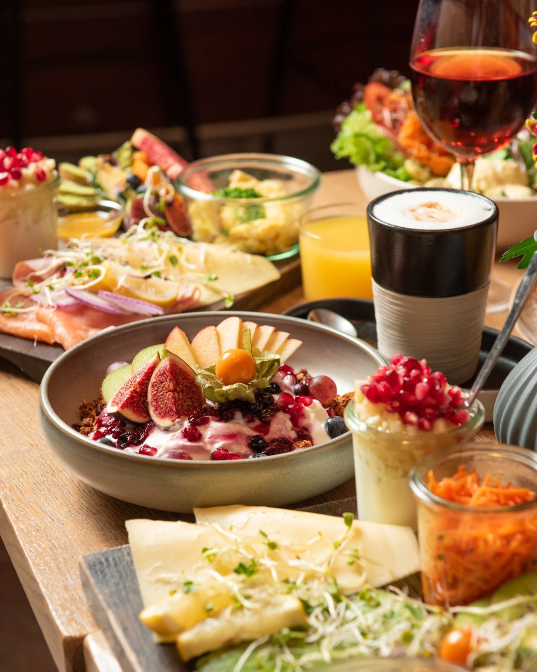 Reichhaltiger Brunch-Tisch im Café Reis Gilching mit Müslischale, Käse, Lachs, Wein und Kaffee