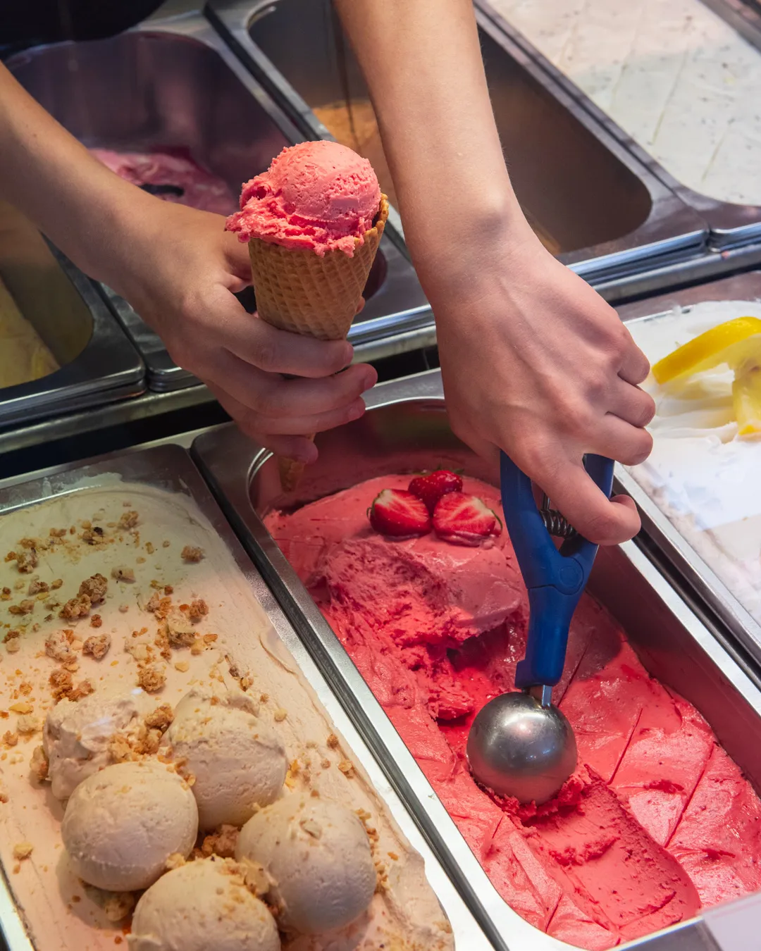 Frisch gekugeltes Erdbeer-Sorbet und Haselnuss-Eis in der Eisdiele im Café Reis Gilching