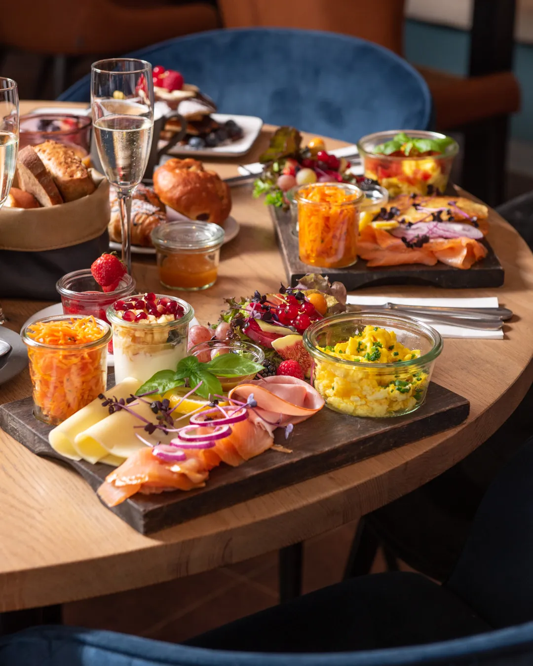 Frühstücksbrettchen mit Räucherlachs, Rührei, Käse, Schinken, Karottensalat, Joghurt und Prosecco im Café Reis